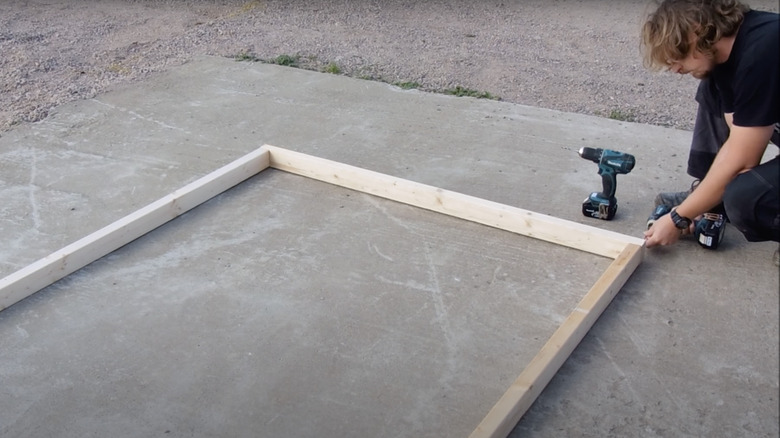 person drilling wooden boards together