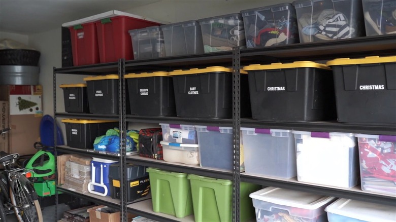 Clear and colored plastic storage totes on rack in garage