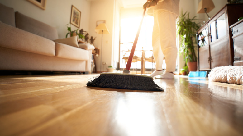 A broom being used on hardwood floors