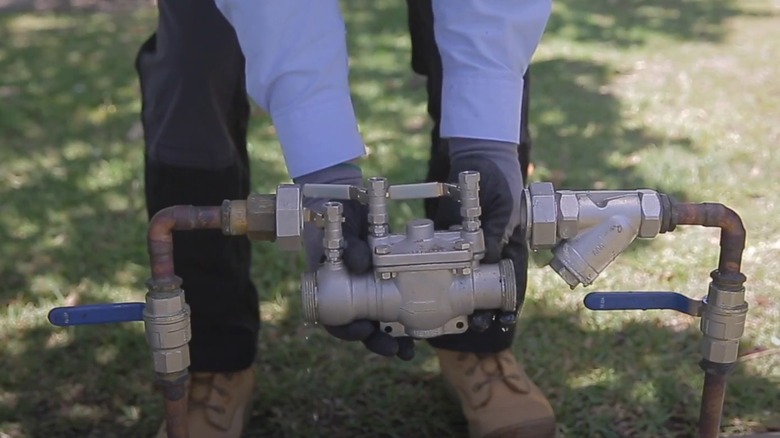 person testing a backflow preventer device