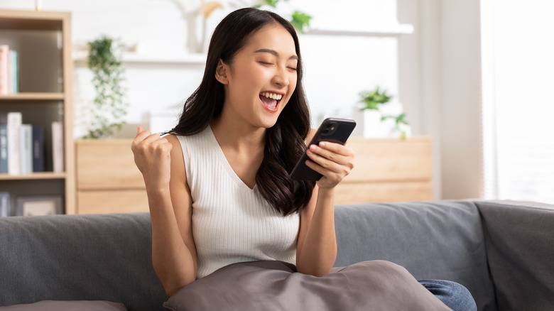 Person reacts happily to phone