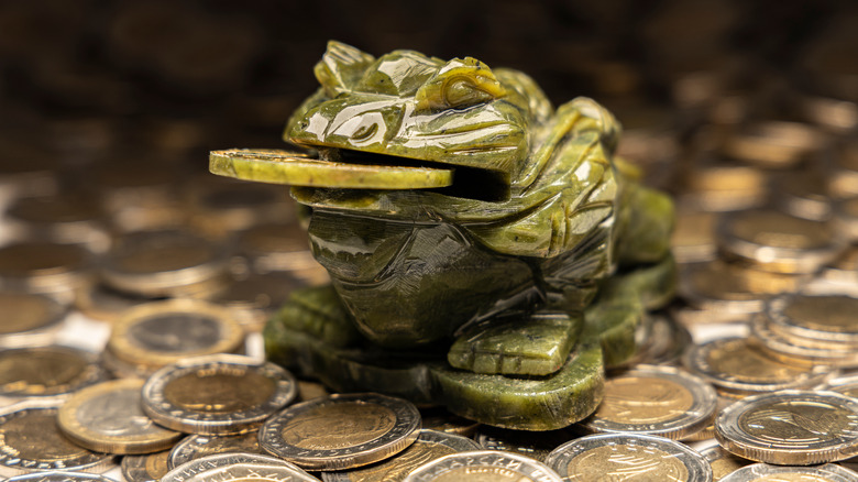 jade frogs sitting on top of coins