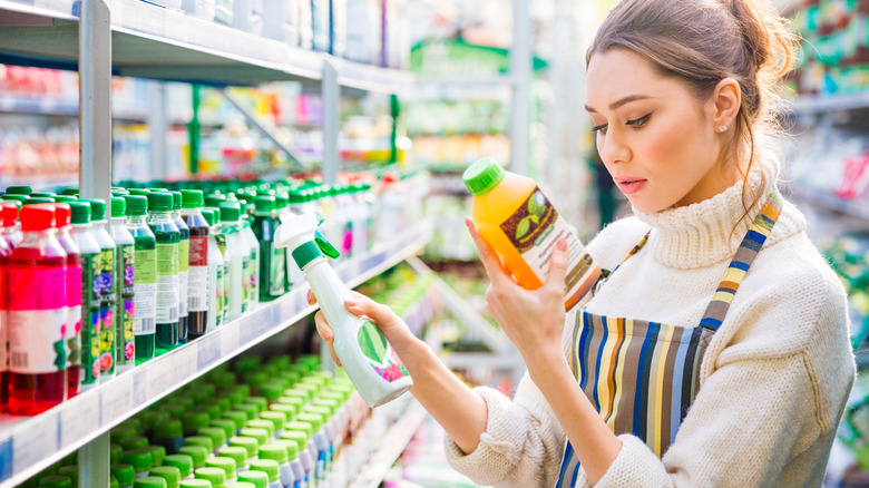 woman holding plant fertilizer bottles