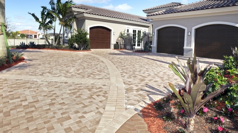 paver driveway leading to three garages in Mediterranean-style home