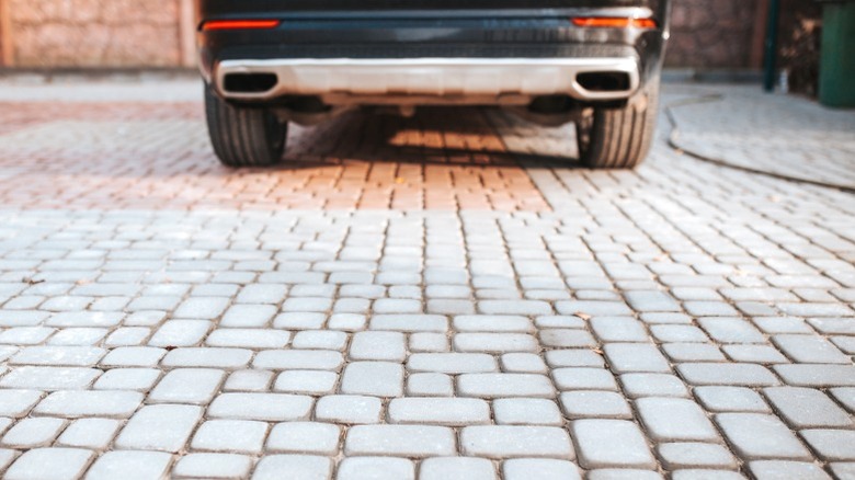 car parked on small paver driveway