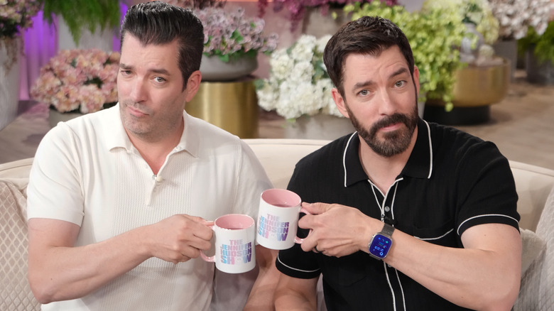 Jonathan and Drew Scott sitting on a couch on a talk show