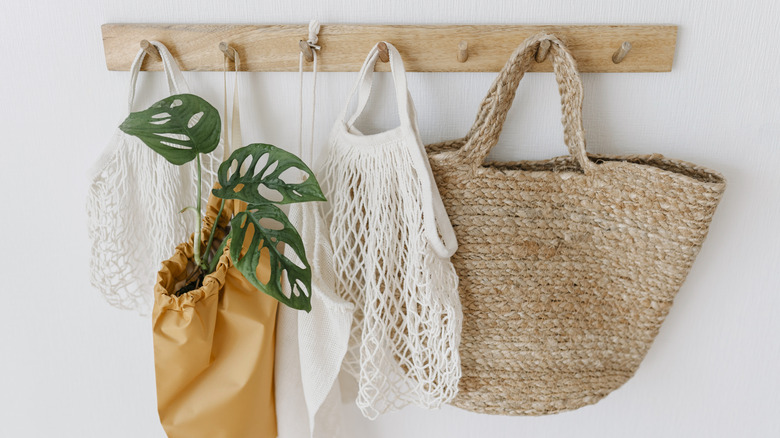 A pale wood peg rack for hats, bags, or light jackets.