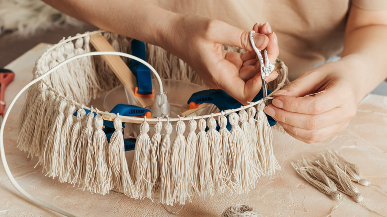 Person fixing lampshade tassels