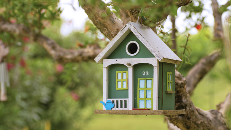 Decorative birdhouse hanging from tree