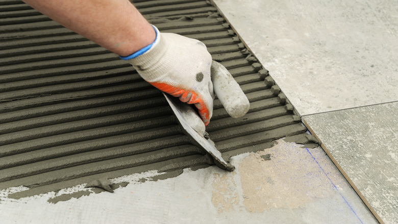 person installing a tile floor