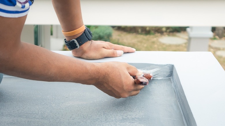 Applying concrete sealer with brush