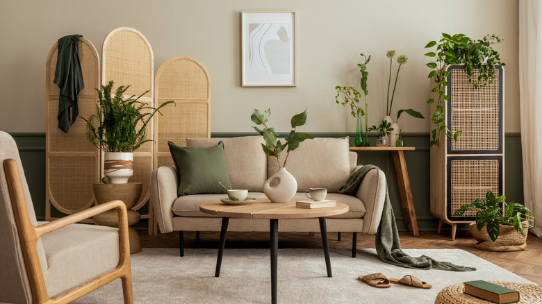 Living room with wooden tables, screen, chair, and plants