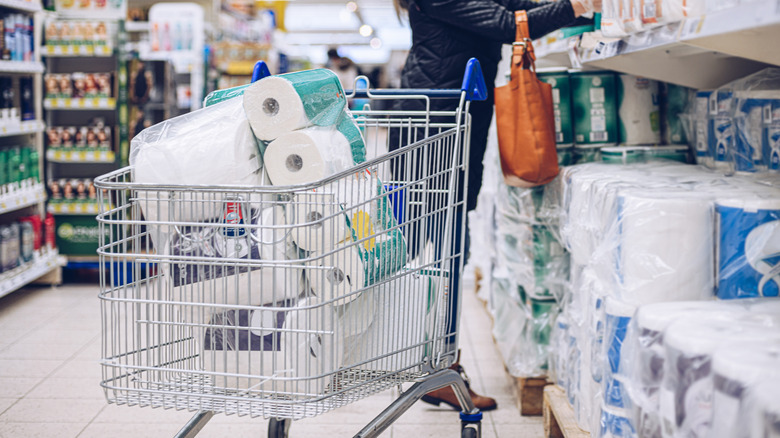 A person with toilet paper in their shopping cart