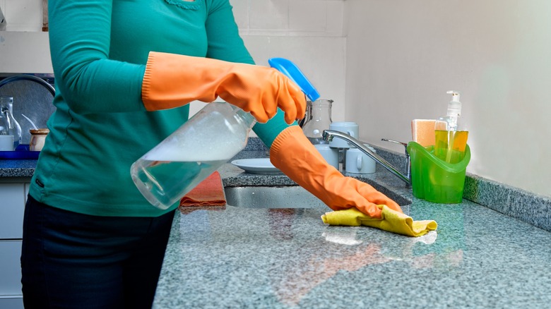 Woman spraying kitchen counter