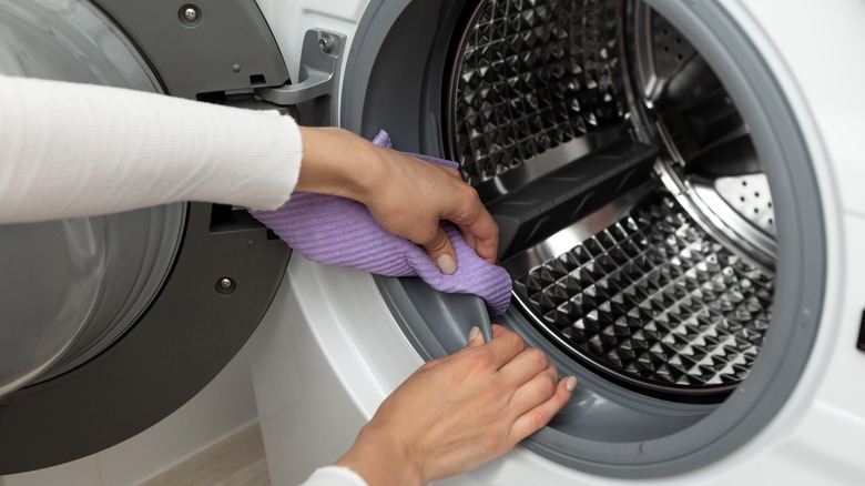 Person cleaning washing machine drum