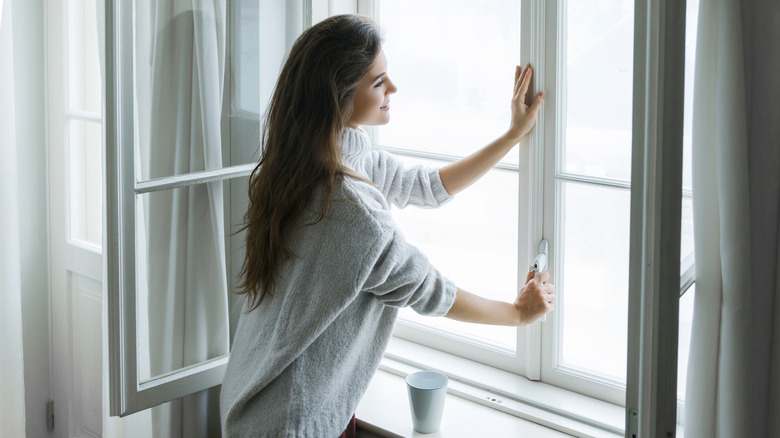 Woman opening windows in winter