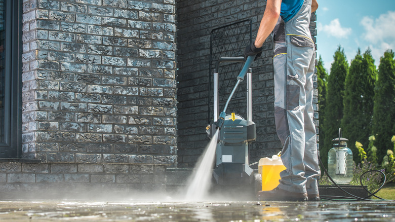 Man pressure washing driveway