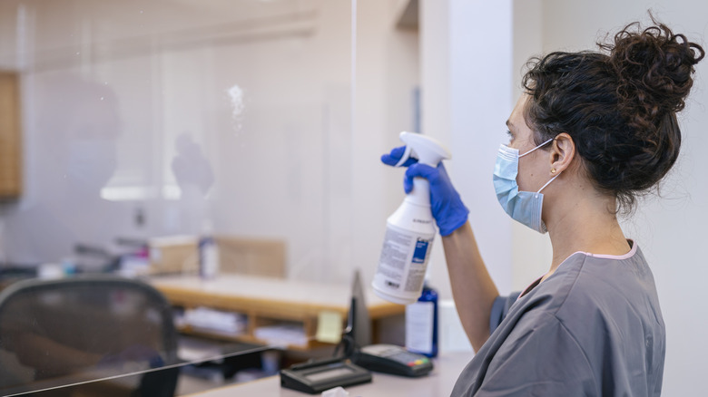 woman cleaning plexiglass