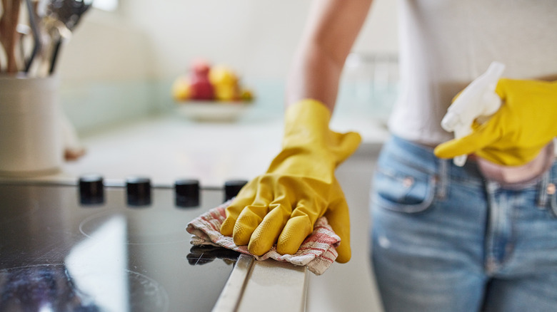 woman cleaning stove top