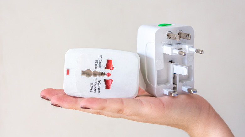 holding two travel outlet adapters