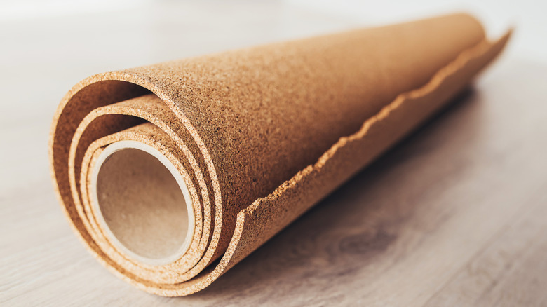 A roll of cork material on a wood background