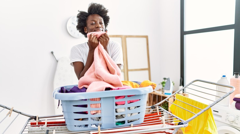 Woman smelling clothing doing laundry 