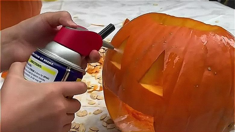 spraying WD-40 into carved pumpkin