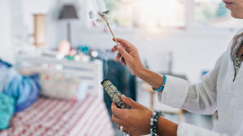 woman burning sage in home