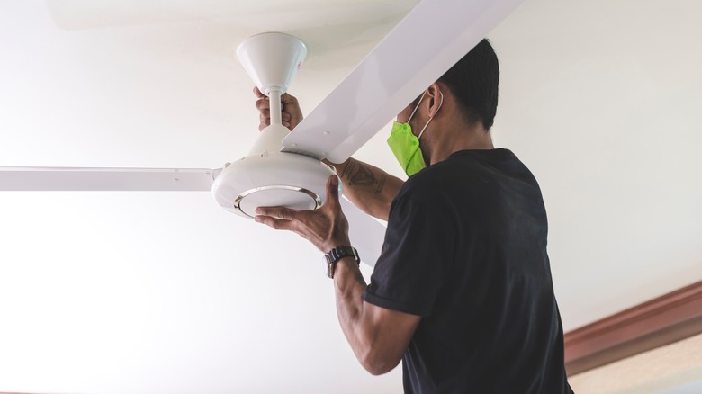 person repairing ceiling fan