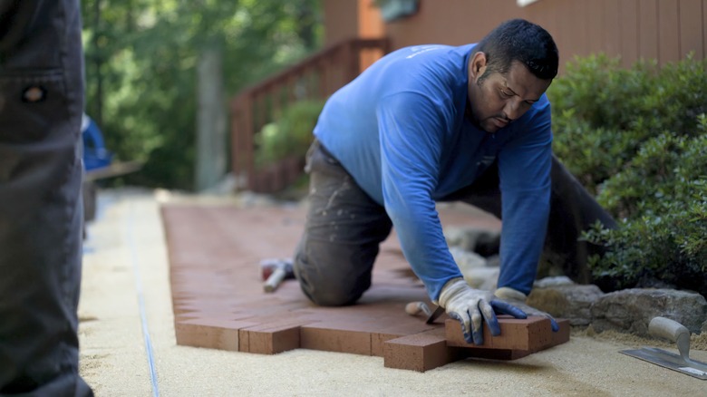 Man installing brick patio