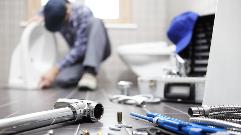 Plumber working on toilet installation