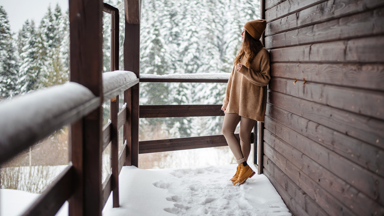 A person standing on a balcony during the winter