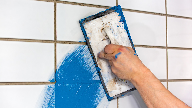 applying blue grout white tile