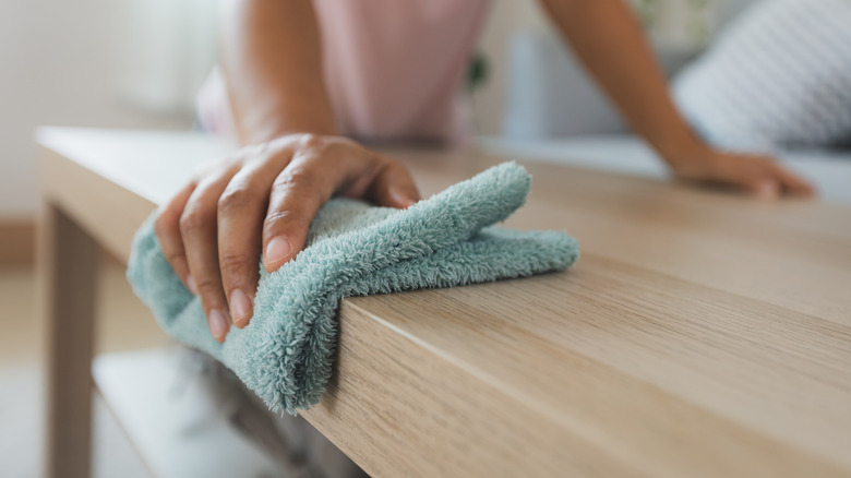 Person dusting table