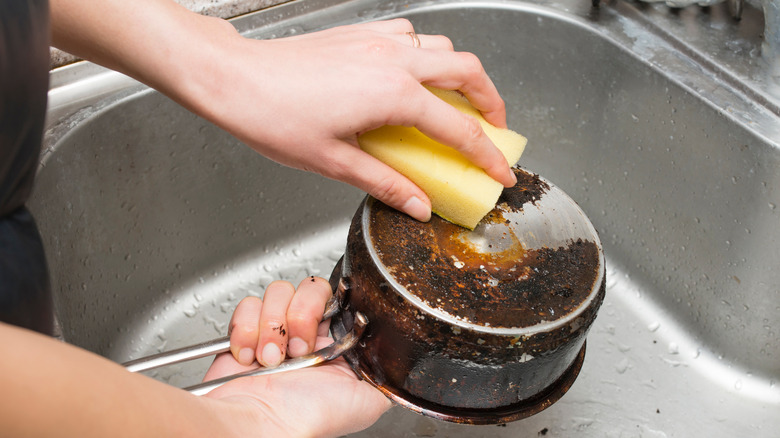 scrubbing dirty burned pan