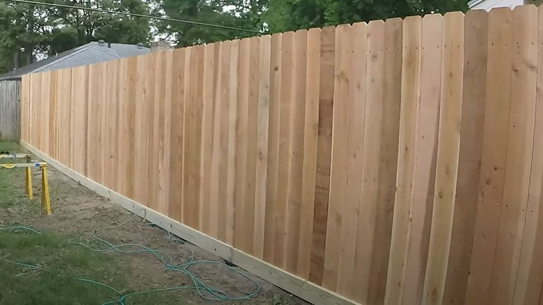 New wooden picket fence with rot boards along the bottom