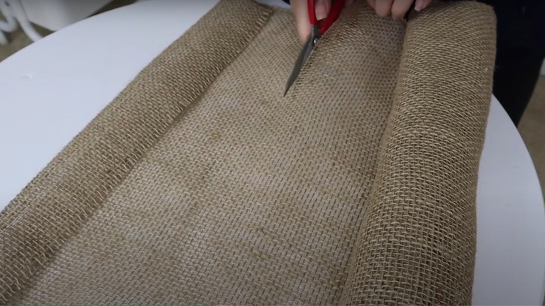 Cutting burlap with scissor