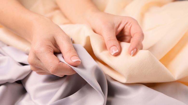 woman comparing fabrics bedsheets