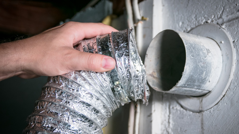 Person removing dryer vent hose