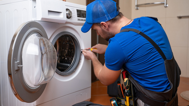 Repairperson checking on washing machine