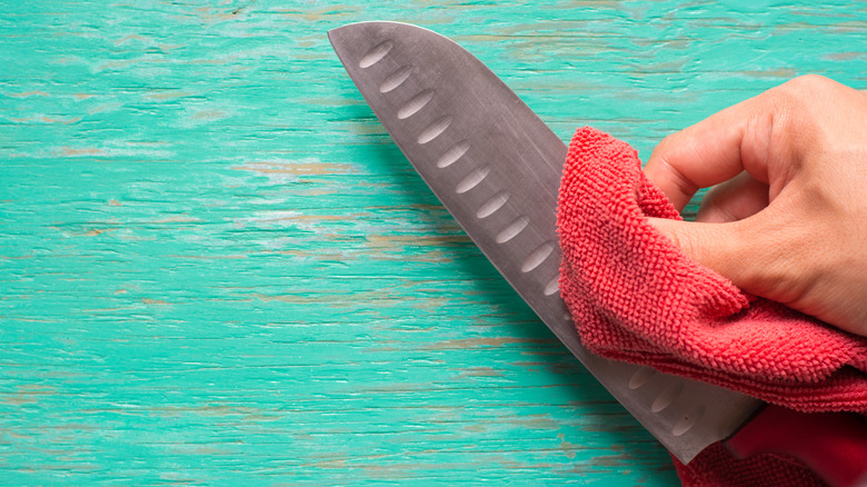 knife being wiped with towel