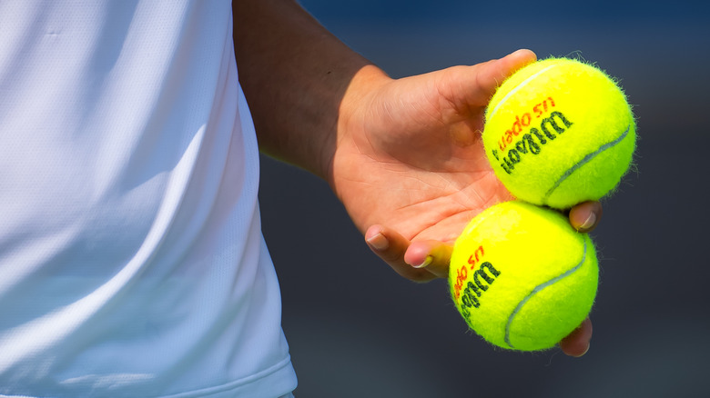 person holding two tennis balls