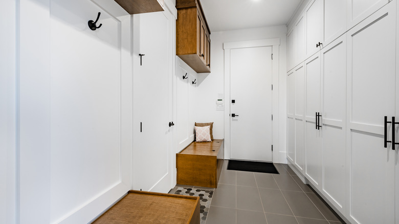 organized entryway with white cabinets