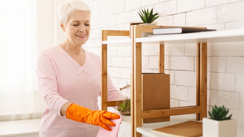 Woman wiping painted shelf