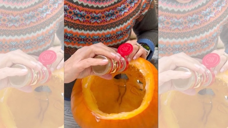 sprinkling cinnamon inside a pumpkin