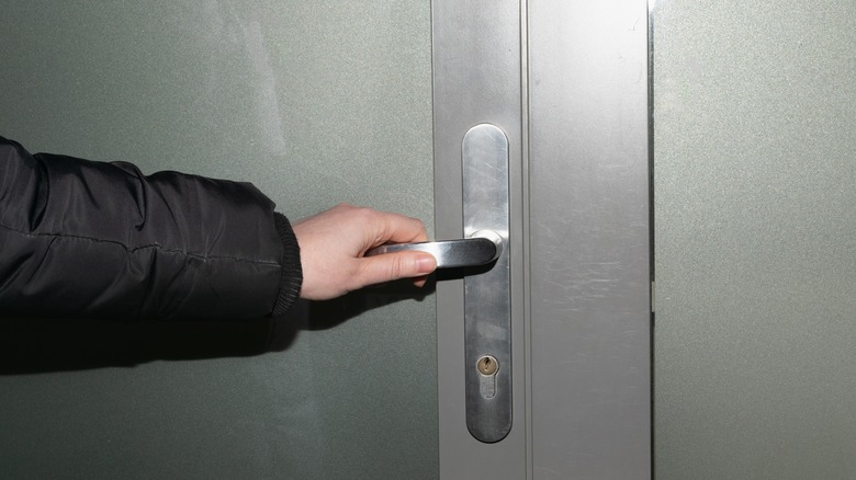 person holding door handle 