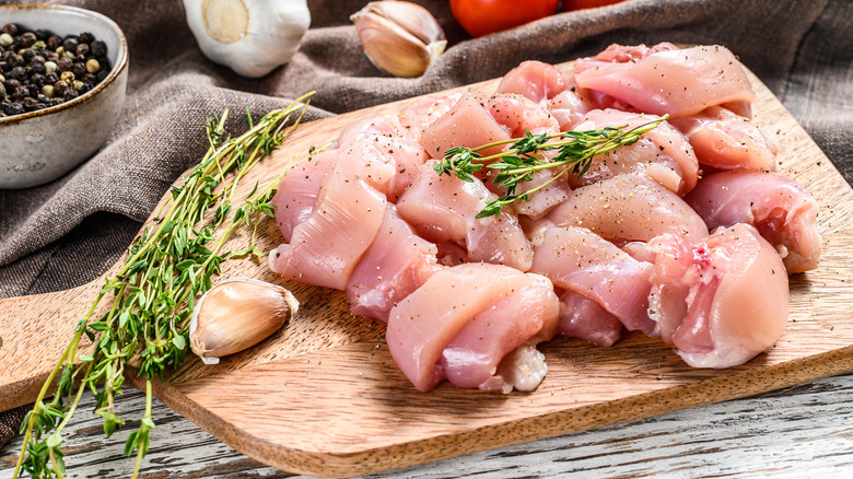 raw chicken on wooden board