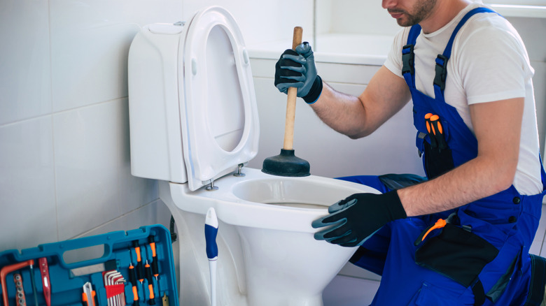 technician repairing toilet bowl