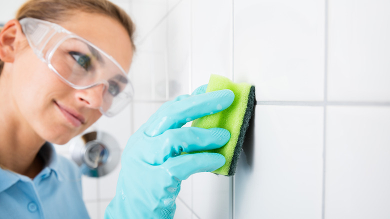 Woman cleaning in goggles and gloves