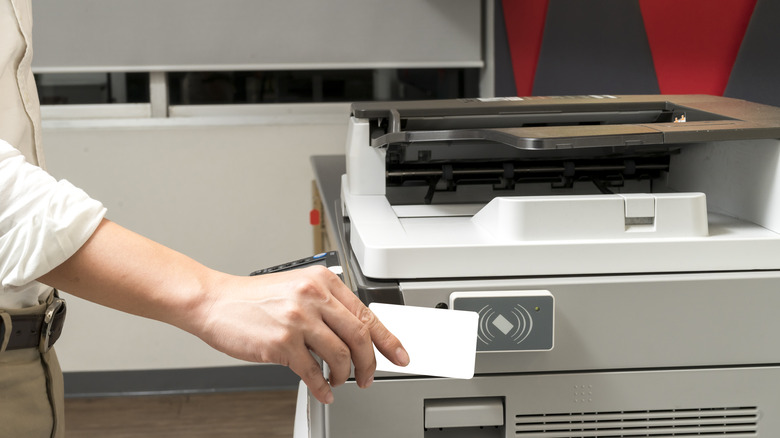 Man holds card to printer